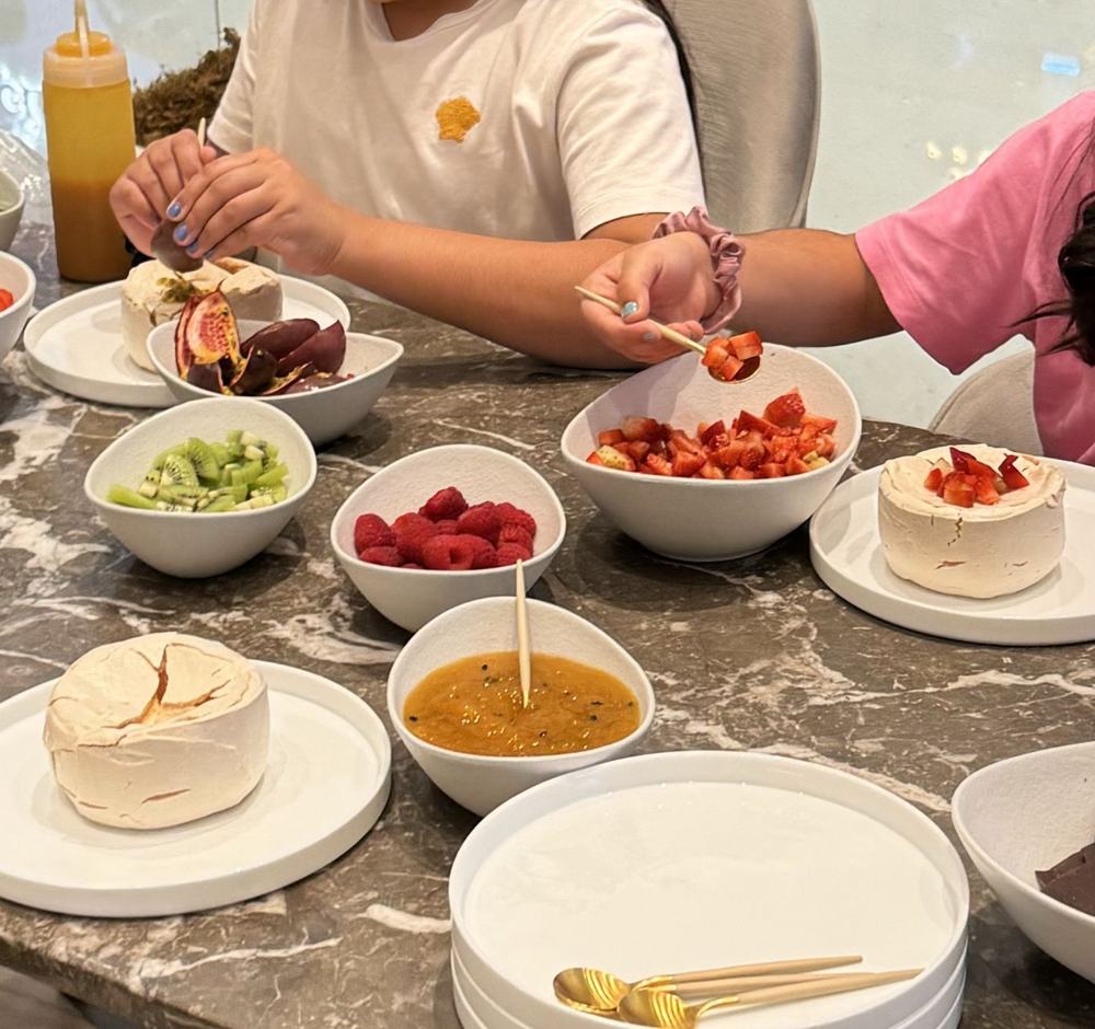 Toppings in bowls next to a meringue base