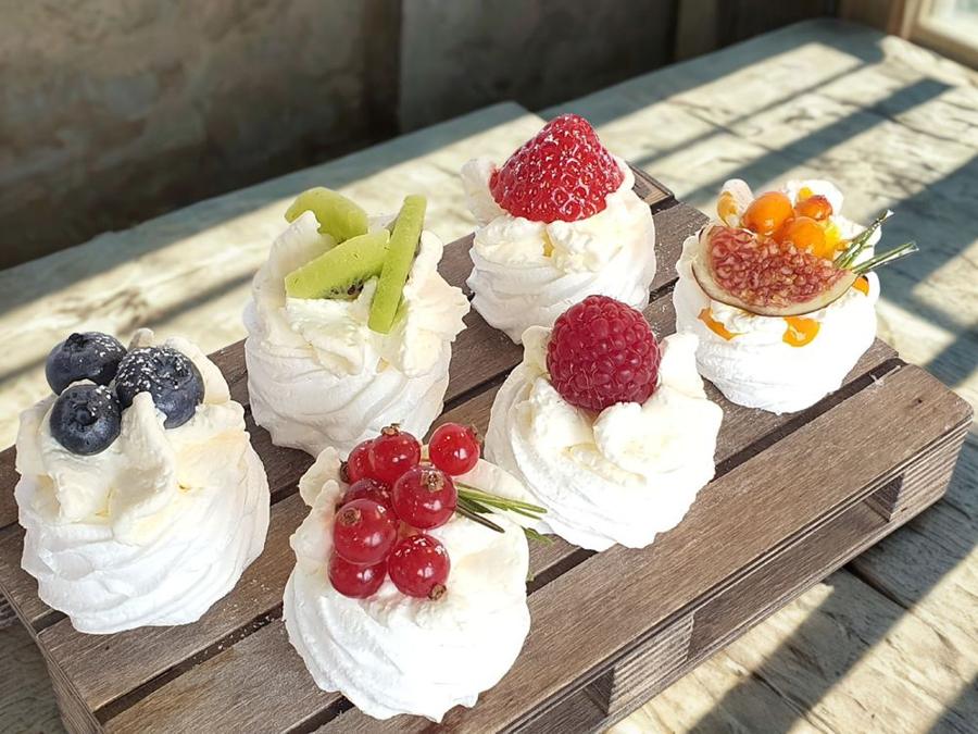 Mini pavlovas with berries on a wooden board
