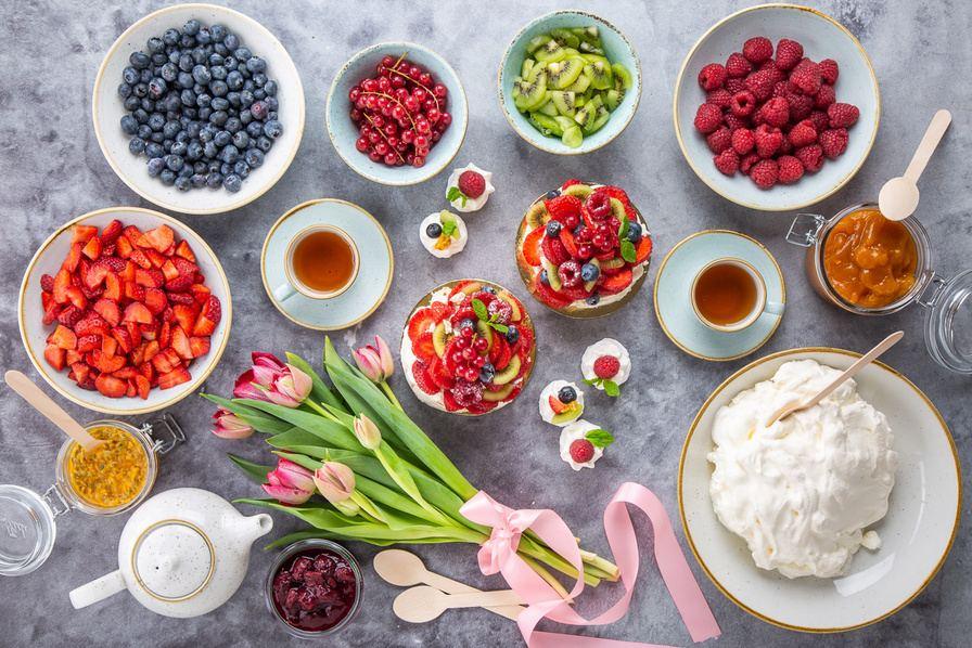 Fresh berries, fruit and cream laid out on a table